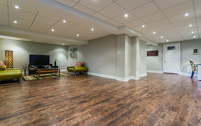 finished basement with vinyl plank flooring, new paint and lighting